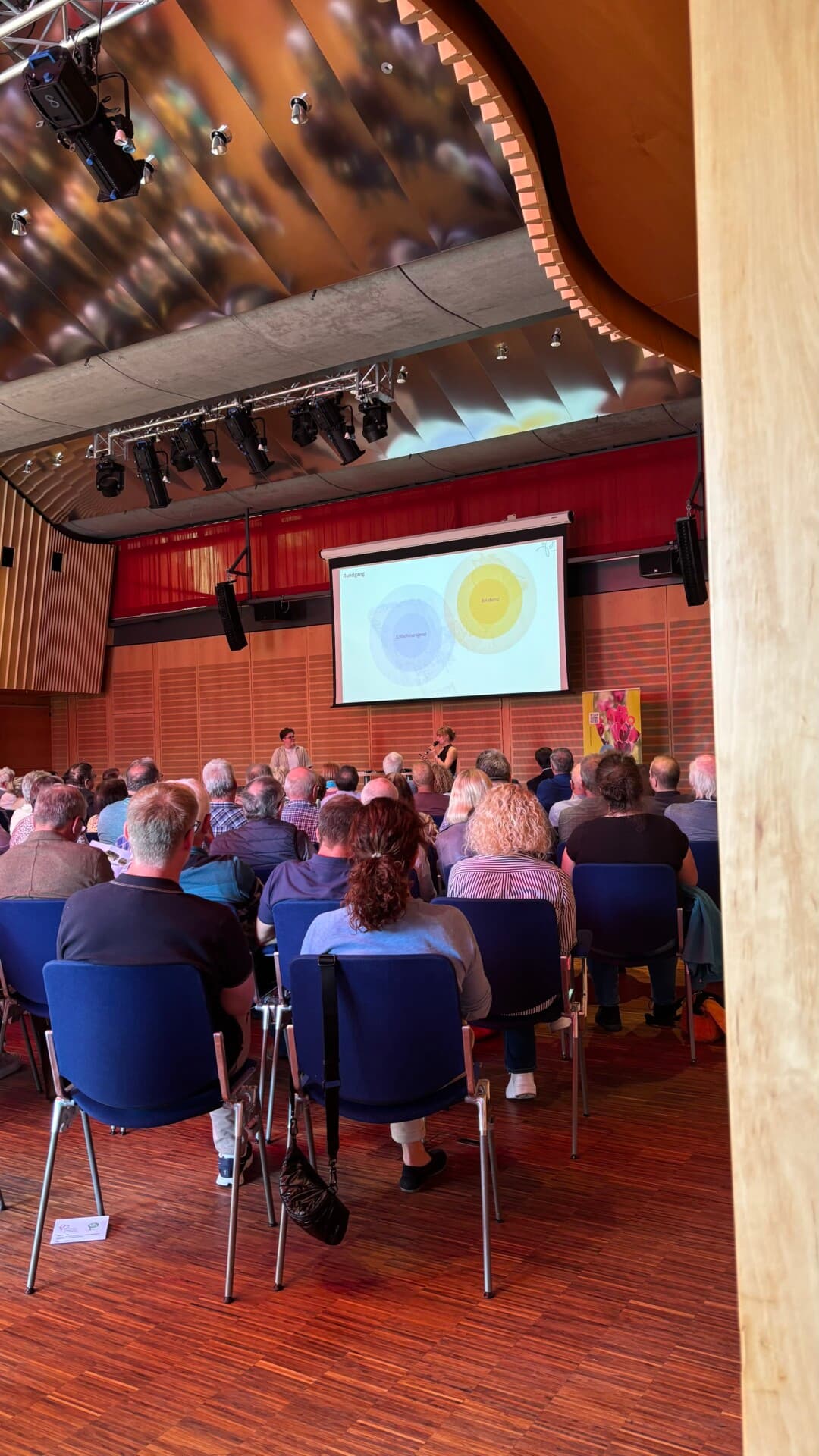 Volles Auditorium im Kur- und Kongress-Center mit Projektion auf der Leinwand